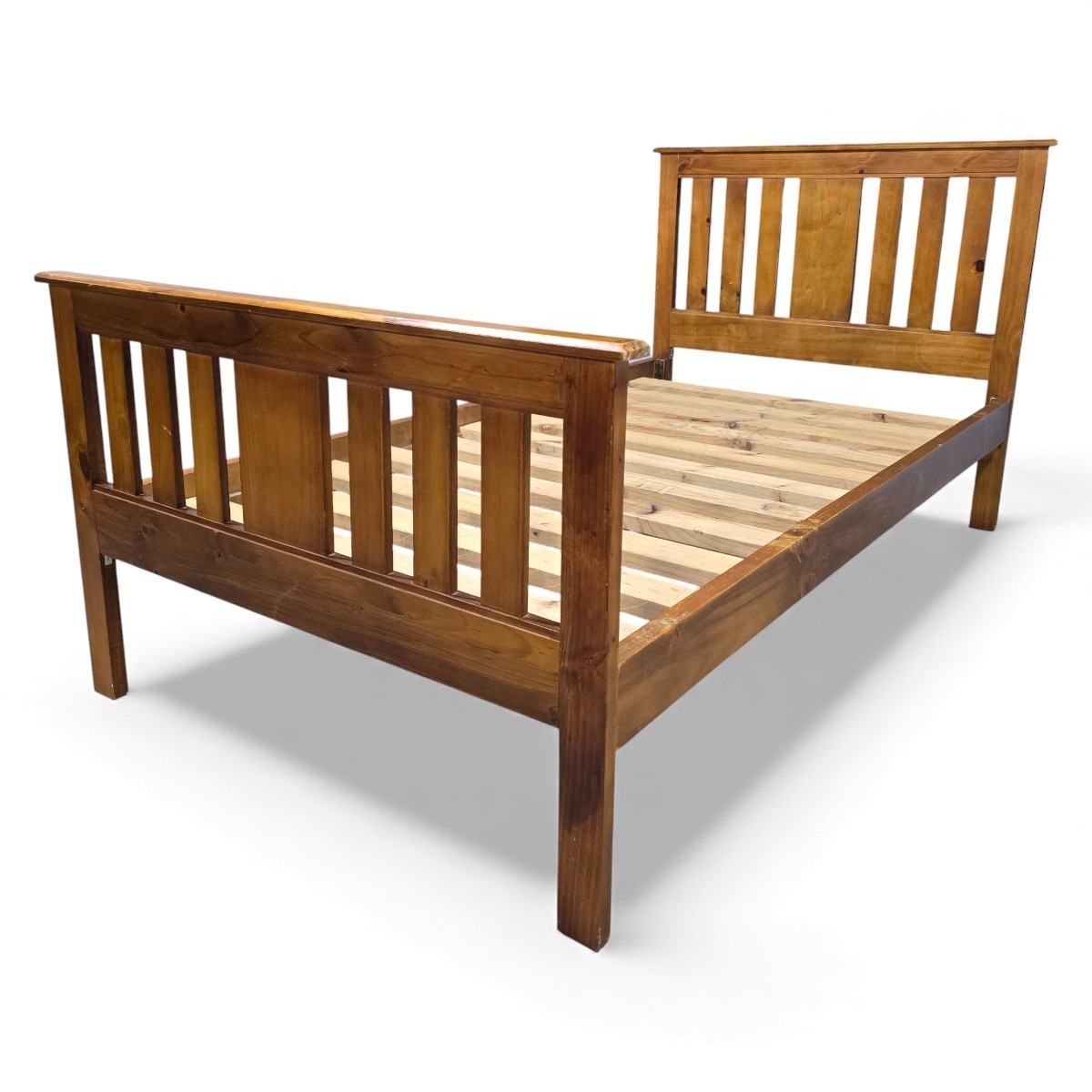 Large single solid pine bed frame with vertical slats and square legs, finished in a warm medium tone, perfect for adding character to any bedroom.